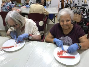 Imagen de un grupo de personas mayores relizando tartaletas de cangrejo